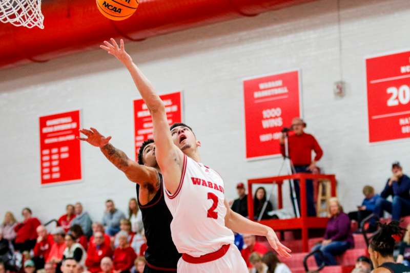 a man in a white jersey jumping to block a basketball