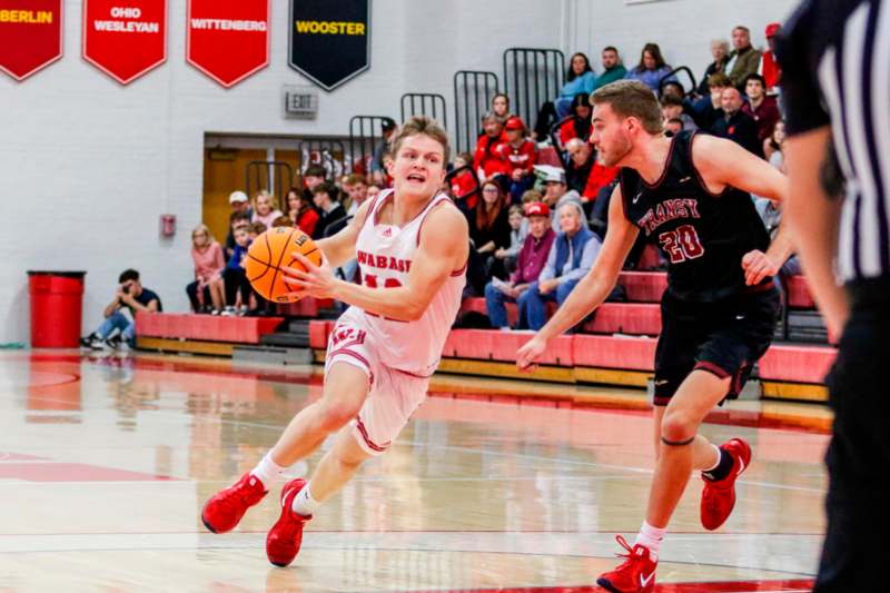 a basketball player running with a basketball in front of a crowd