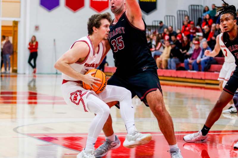 a basketball player in a red uniform with a basketball in the air