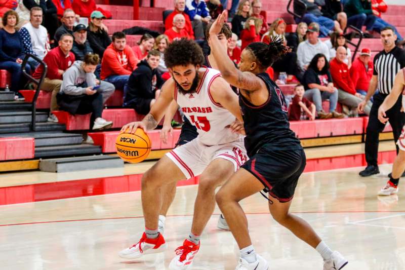 a basketball player in a red uniform with a basketball in front of a crowd