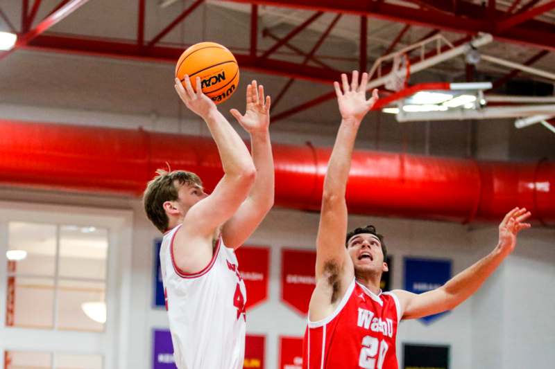 two men playing basketball in a gym