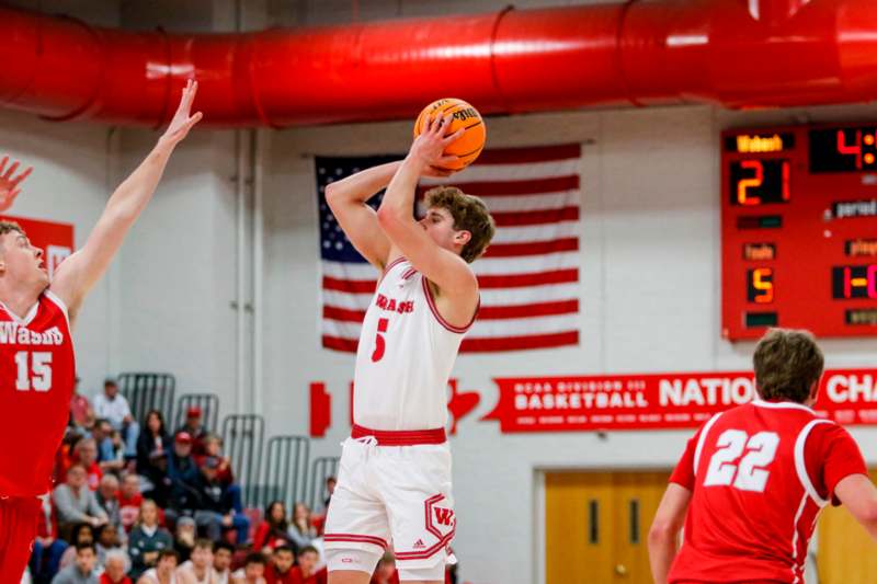 a basketball player in a white uniform with a red jersey and a red ball in the air