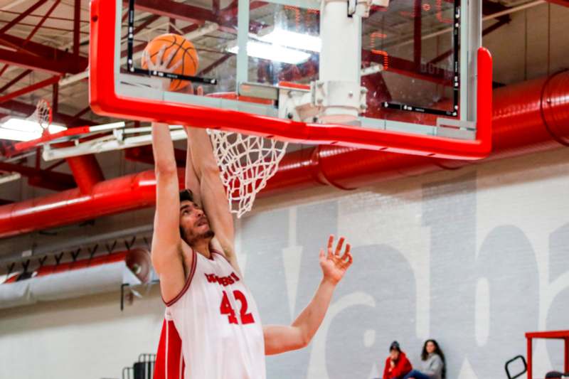 a man in a basketball uniform dunking a basketball