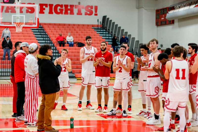 a group of men in sports uniforms clapping