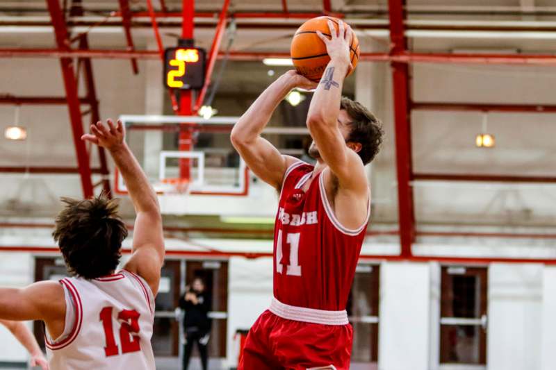 a basketball player in red uniform with a ball in the air