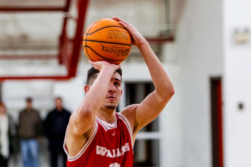 a man in a basketball uniform holding a basketball