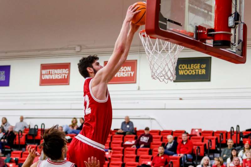 a man dunking a basketball in a gym