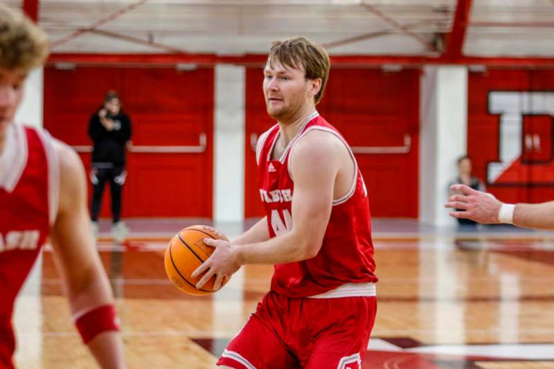 a man in a red uniform holding a basketball