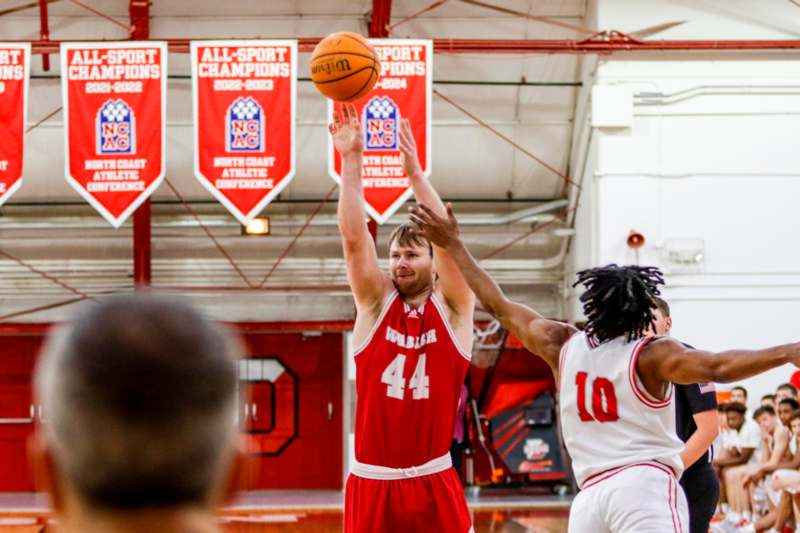 a basketball player in a red uniform with a ball in the air