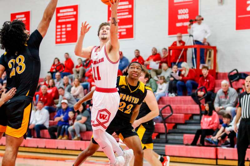 a basketball player in a red uniform jumping to shoot a basketball