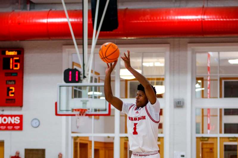 a man in a white jersey with a red number on his shirt and a basketball