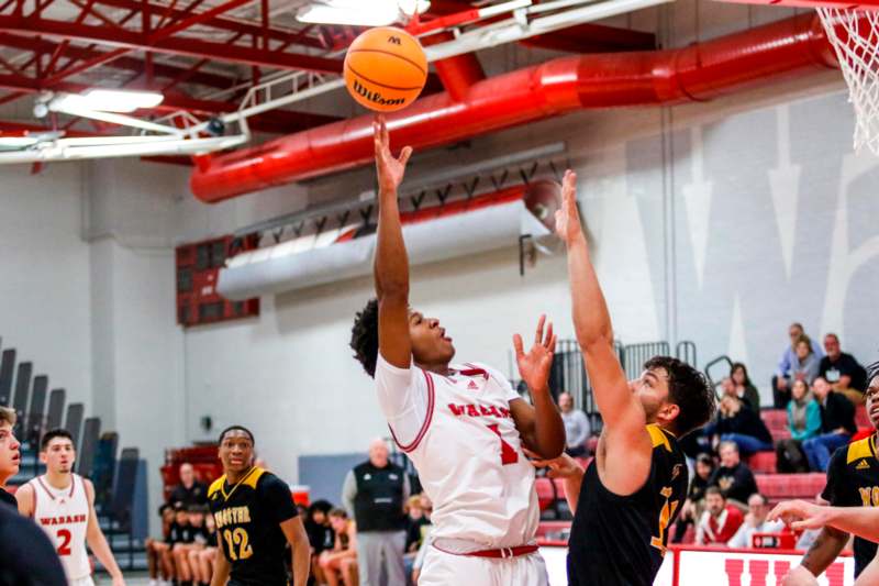 a basketball player reaching for a ball