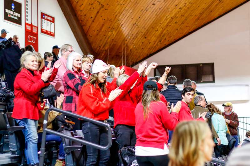 a group of people in red shirts clapping