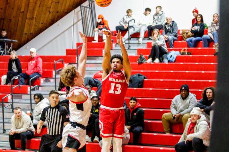 a basketball player in a red uniform shooting a ball