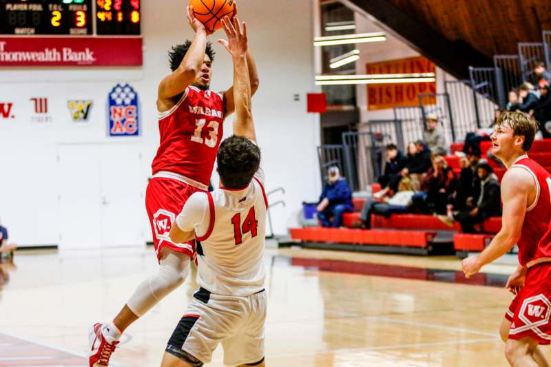 a basketball player in red and white uniform jumping to shoot a basketball