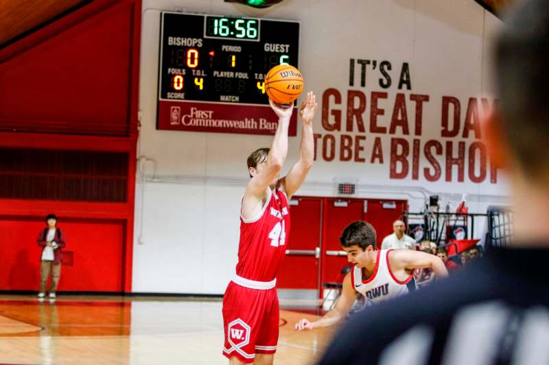 a basketball player in a red uniform with a basketball in the air