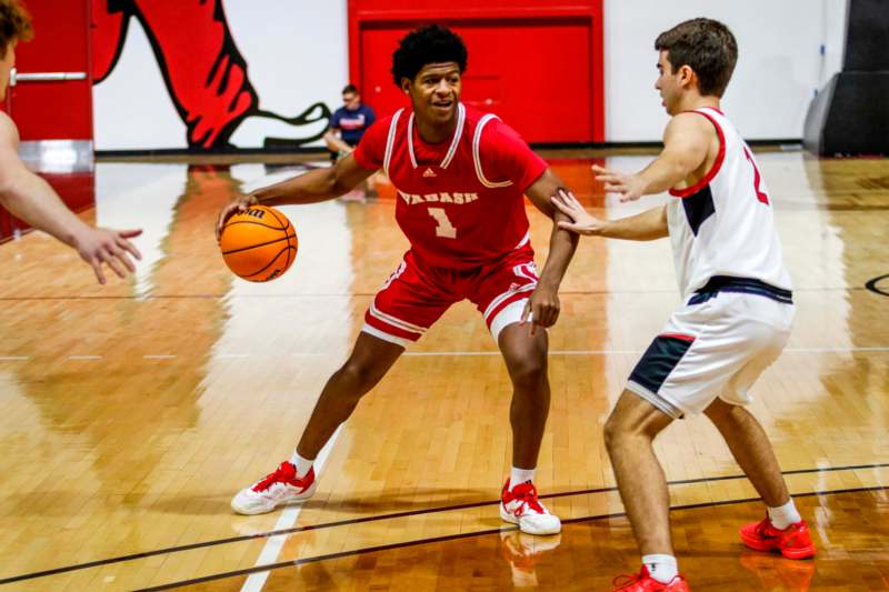 a man in a red uniform dribbling a basketball