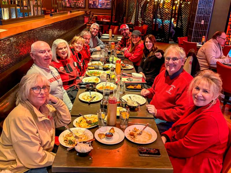 a group of people sitting at a table with food