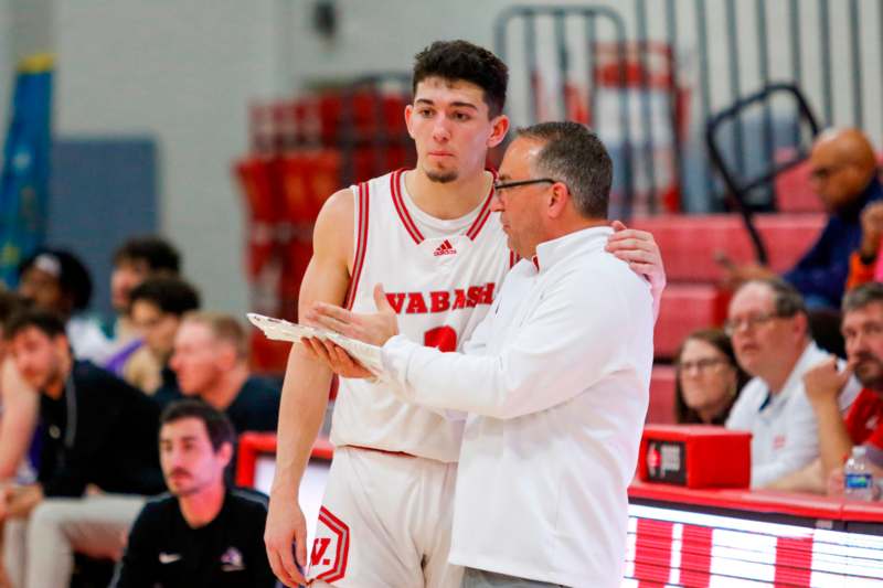 a man in a white shirt and a man in a white shirt standing next to a man in a red and white uniform