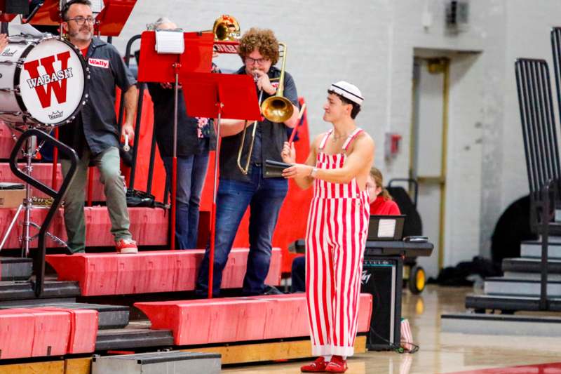 a man in striped overalls playing a trumpet