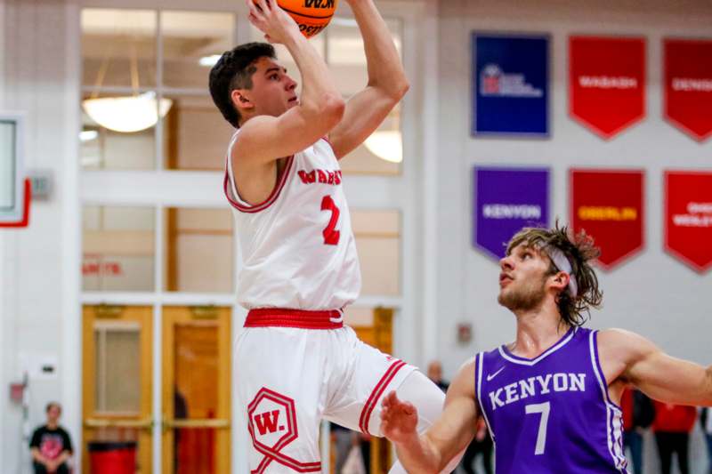 a basketball player in a uniform jumping to shoot a basketball