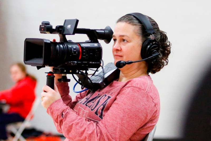 a woman with headphones holding a camera