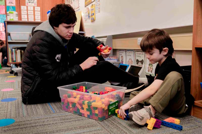 a man and boy playing with colorful blocks