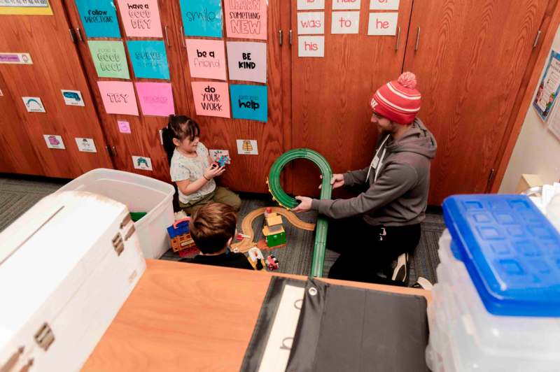 a man and two children playing with toys