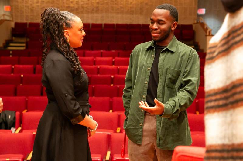 a man and woman talking in a theater