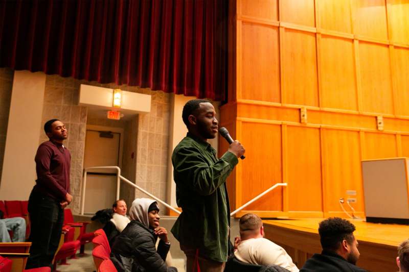 a man holding a microphone in front of a crowd