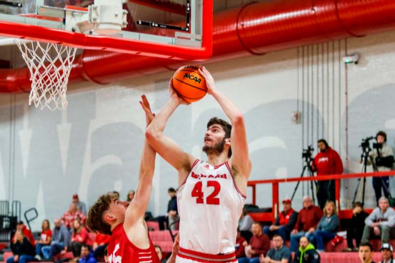 a basketball player in a red uniform making a dunk