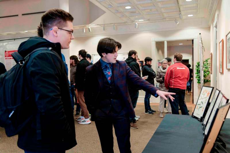 a man in a suit pointing at a table