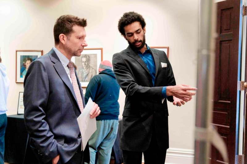 a group of men in suits looking at something