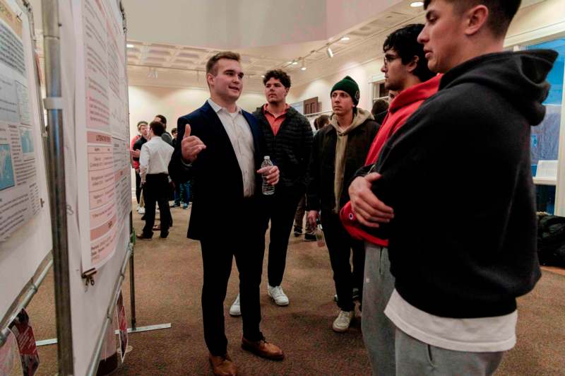 a man standing in front of a poster