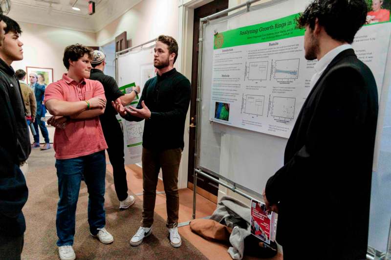 a group of men standing in front of a poster