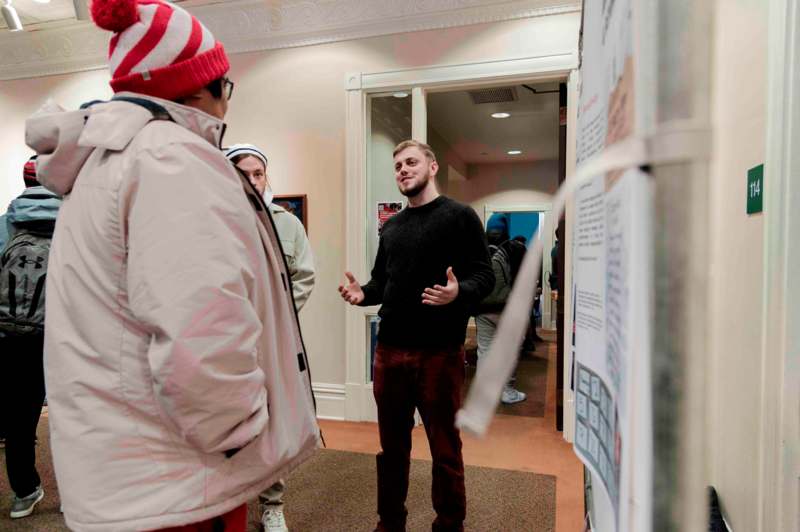 a man standing in a hallway with a group of people