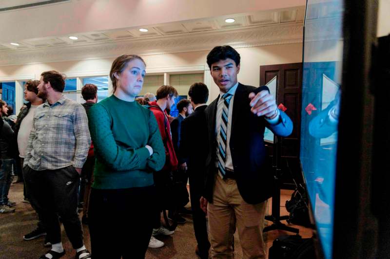 a man and woman standing in a room with a glass wall