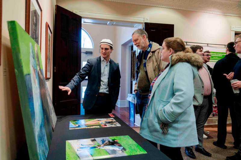 a group of people looking at a piece of art