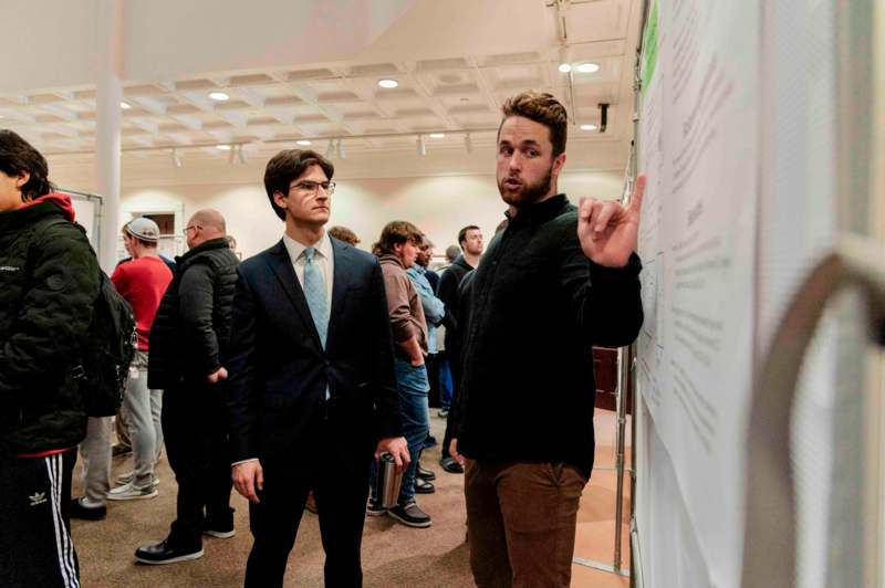 a man pointing at a white board