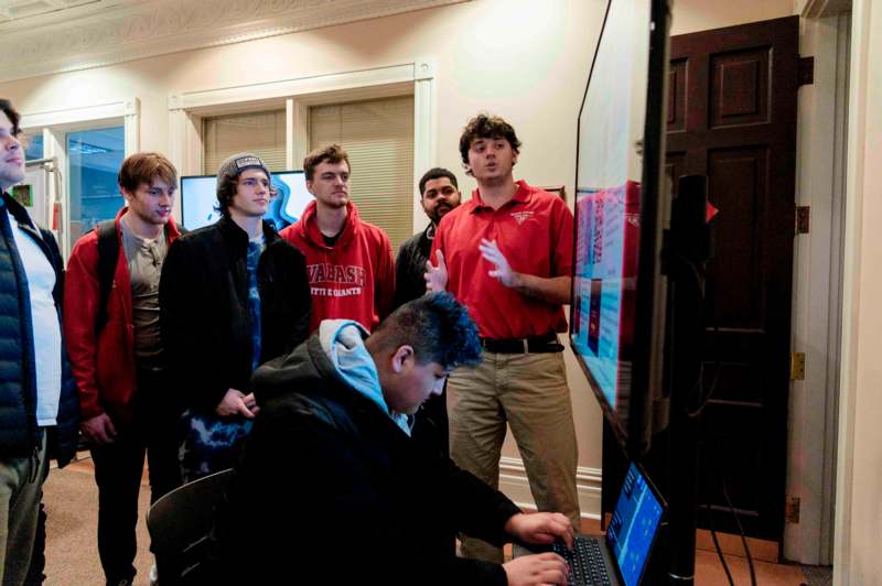 a group of people standing around a computer