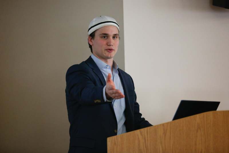 a man in a suit and hat giving a hand shake