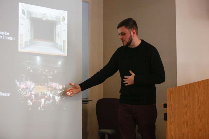 a man standing in front of a projection screen