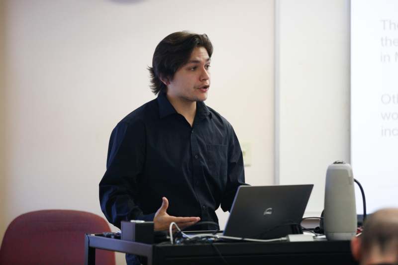 a man standing in front of a laptop