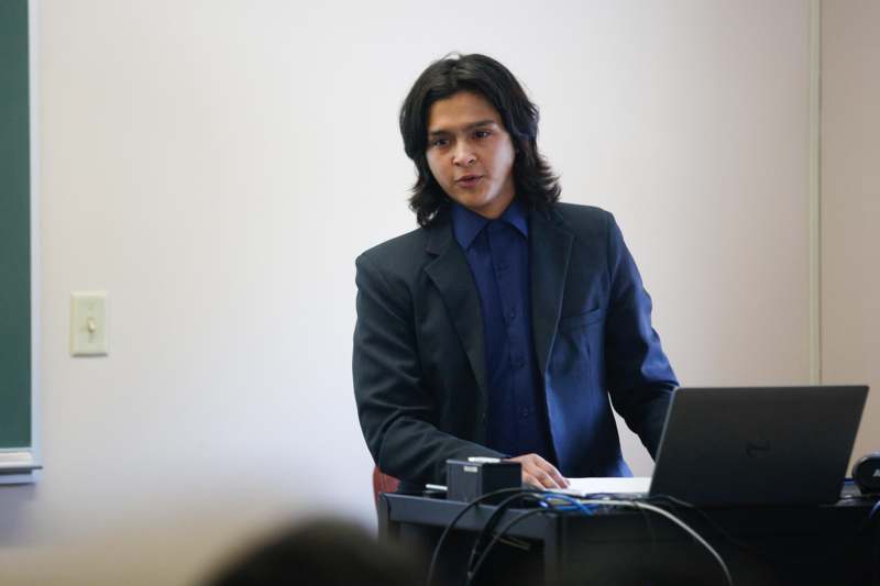 a man in a suit sitting at a desk with a laptop