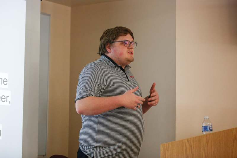 a man in glasses standing in a room