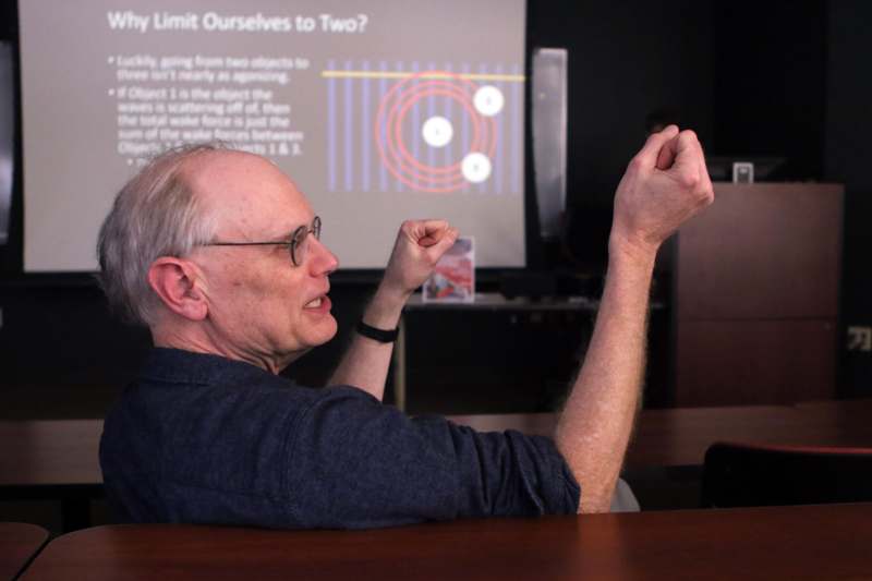 a man sitting at a desk with his fist up