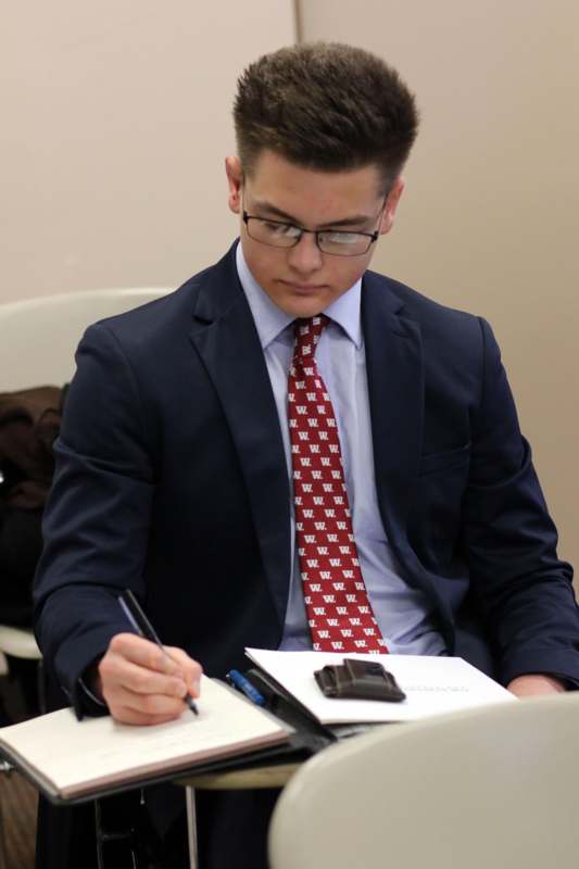 a man in a suit writing on a paper