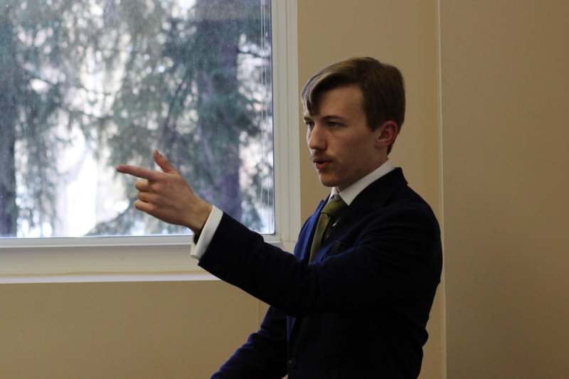 a man in a suit pointing at a window