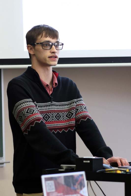 a man wearing glasses and a sweater