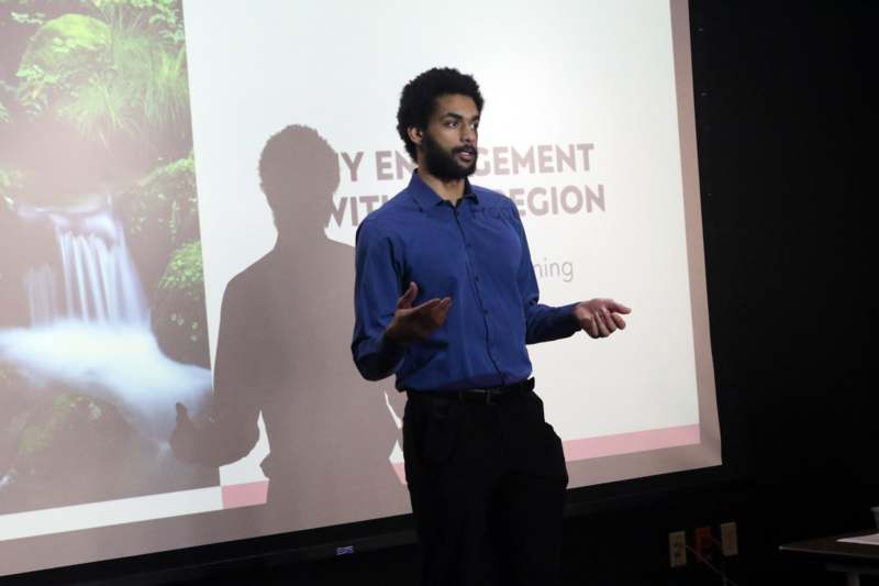 a man standing in front of a projection screen